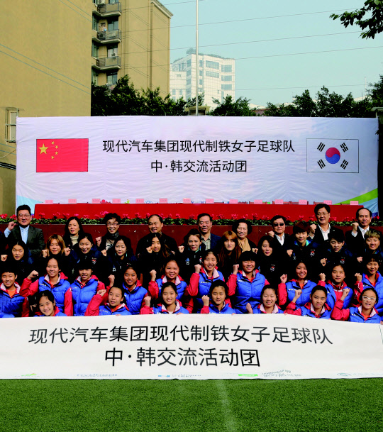 현대제철 관계자들이 지난 7일 중국 충칭시 소재 따핑중학교에서 유소녀 축구 발전을 위한 한·중 교류 업무협약(MOU)을 맺은 뒤 기념촬영하고 있다. <현대제철 제공>
